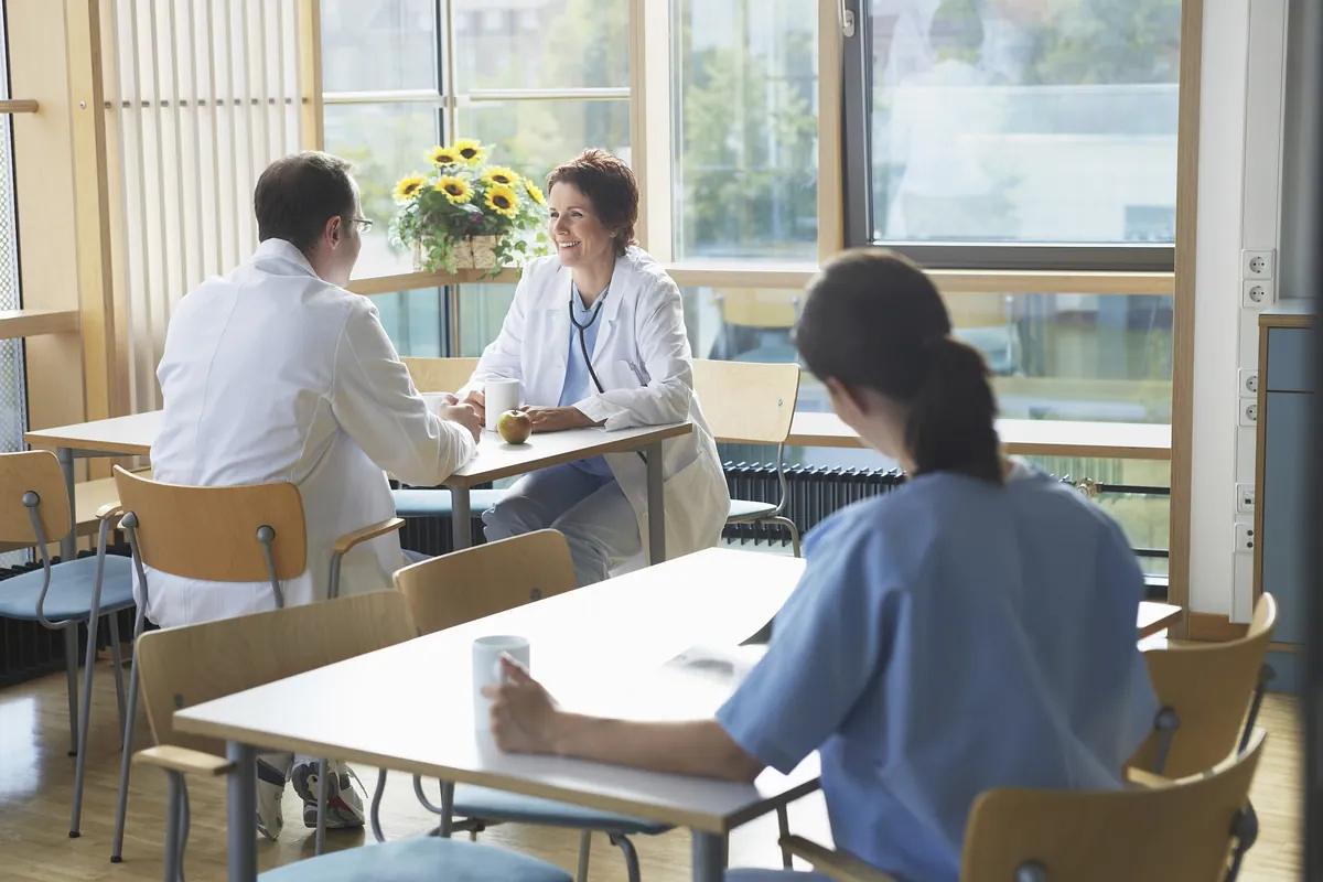 Scientists and engineers in conversation in a bright break room